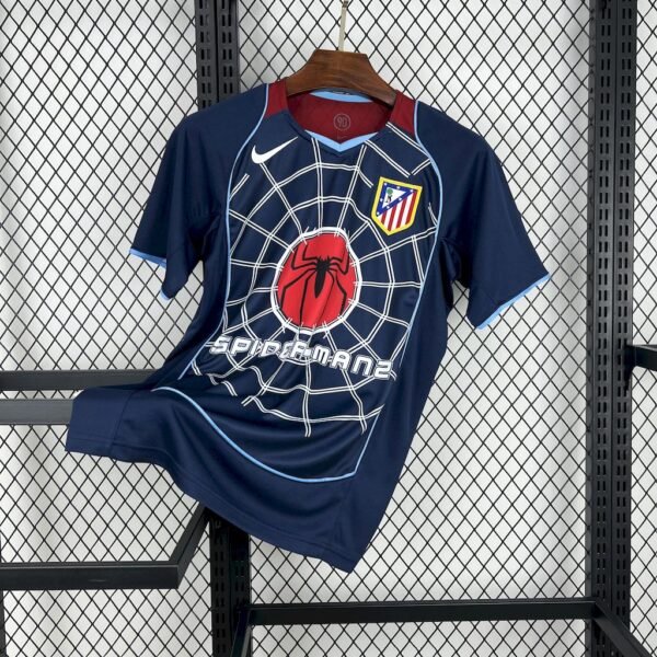 Camiseta visitante Atlético de Madrid 2004-05 azul marino con franja diagonal roja y blanca, logo Spiderman 2 y patrocinio Columbia Pictures