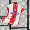Camiseta local Atlético de Madrid 1999-2000 con franjas rojas y blancas, cuello tipo polo, escudo bordado y patrocinio de Marbella