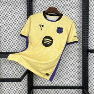 Camiseta visitante FC Barcelona 2025‑26 color dorado claro con detalles en violeta persa y negro, escudo bordado y logo de Kobe Bryant