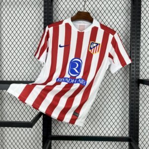 Camiseta local Atlético de Madrid 2025‑26 en rayas rojas y blancas con cuello rojo y blanco inspirado en el T90, escudo bordado y logotipos azules