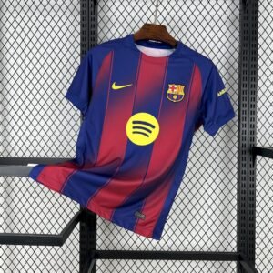 Camiseta local FC Barcelona 2025‑26 en rayas verticales rojas y azul oscuro con transición gradual, escudo bordado y logotipos amarillos