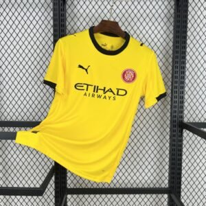 Camiseta visitante Girona FC 2025-26 en color blanco con detalles en rojo y negro, escudo bordado y diseño moderno