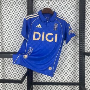 Camiseta local Real Oviedo 2025‑26 azul con detalles dorados, cuello polo y diseño a cuadros sutil