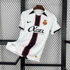 Camiseta visitante RCD Mallorca 2025‑26 blanca con franja central negra y roja, detalles en negro y escudo bordado