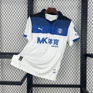 Camiseta visitante Deportivo Alavés 2025‑26 blanca con degradado de negro a azul, escudo albiazul y detalles del himno del club