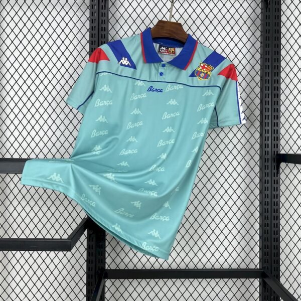 Camiseta visitante FC Barcelona 1992-95 en aqua claro con detalles en azul y rojo, cuello tipo polo y escudo bordado