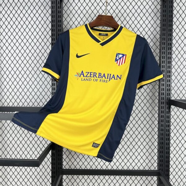 Camiseta visitante Atlético de Madrid 2013-14 en amarillo y azul marino, escudo bordado, logo Nike y patrocinio Azerbaijan Land of Fire