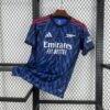 Camiseta visitante Arsenal 25/26 azul marino con rayos azul real, detalles rojos y logos en plata metálica