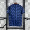 Camiseta visitante Arsenal 25/26 azul marino con rayos azul real, detalles rojos y logos en plata metálica