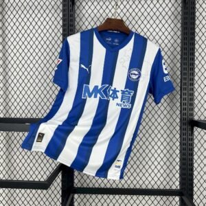 Camiseta local Deportivo Alavés 2025‑26 con franjas verticales azul y blanco, cuello redondo y escudo con mapa de Álava