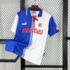Camiseta tercera Atlético de Madrid 1996-97 con diseño dividido en blanco y azul, escudo bordado, logo Puma y patrocinio Bandai