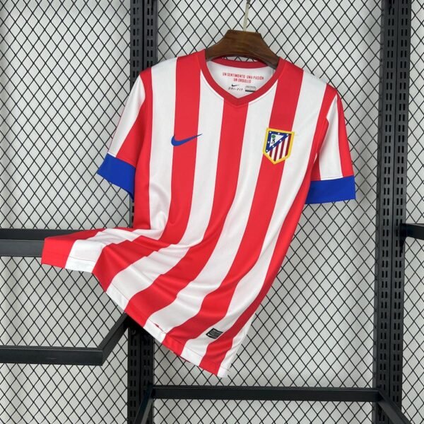 Camiseta local Atlético de Madrid 2012-13 con franjas rojas y blancas, cuello redondo, escudo bordado y logo Nike