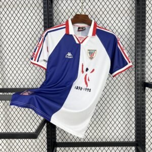 Camiseta visitante Athletic Club 1997‑98 con diseño dividido en blanco y azul marino, cuello tipo polo rojo y detalles en las mangas