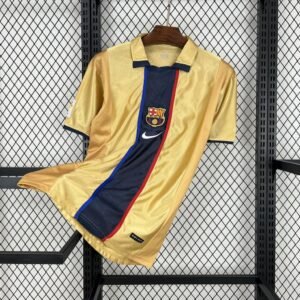 Camiseta visitante FC Barcelona 2001-02 dorada con detalles en azul marino y rojo, cuello tipo polo y escudo bordado